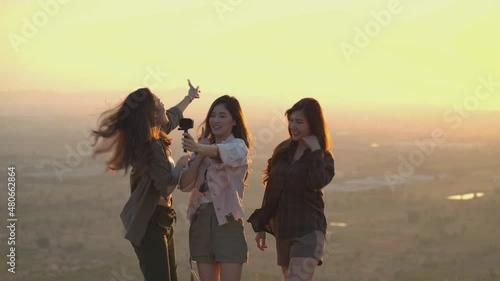 Friend group of Asian young women having fun and enjoy on a summer vacation vlogging from the mountain in nature during sunset. Females Lifestyle, blogger travel photo