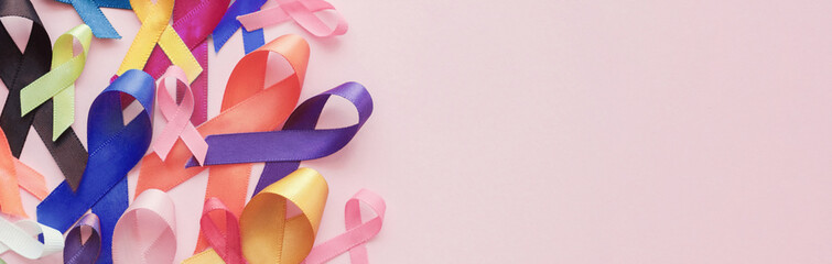 Multicolour ribbons on pink background, cancer awareness, World cancer day