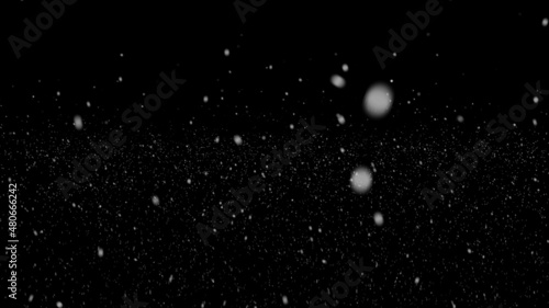 Real snow on black background. Falling snow at night. Bokeh lights on black background, flying snowflakes in the air. Overlay texture. Snowstorm