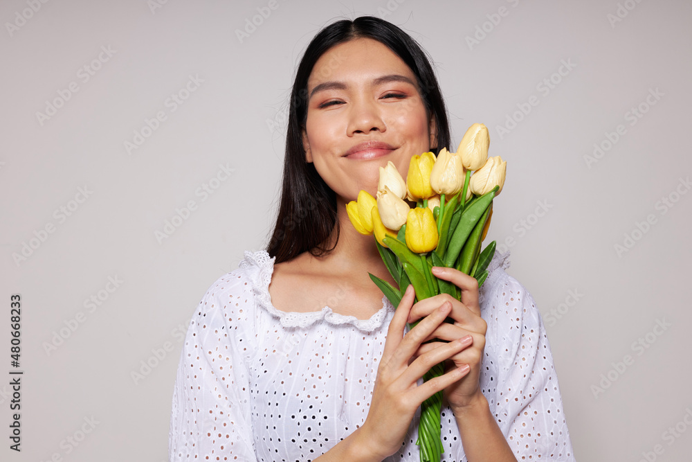 pretty brunette with a bouquet of flowers smile close-up isolated background unaltered pretty brunette with a bouquet of flowers smile close-up isolated background unaltered