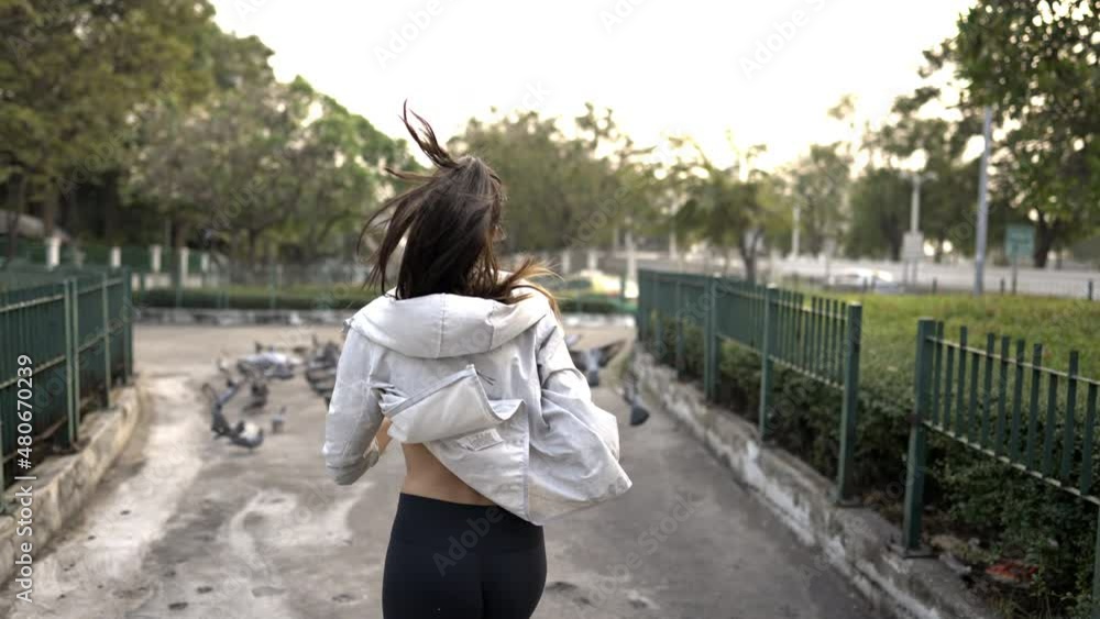 4K Confidence Hispanic woman in sportswear jogging in city street at summer sunset. Healthy wellness female athlete enjoy urban outdoor lifestyle sport training workout fitness exercise and running