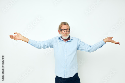 old man in blue shirts gestures with his hands isolated background