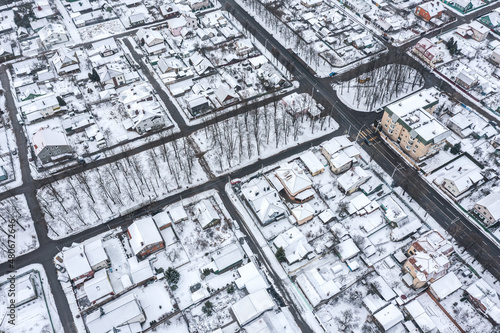 winter cityscape. suburb residential area covered with snow. top view aerial photo from flying drone.