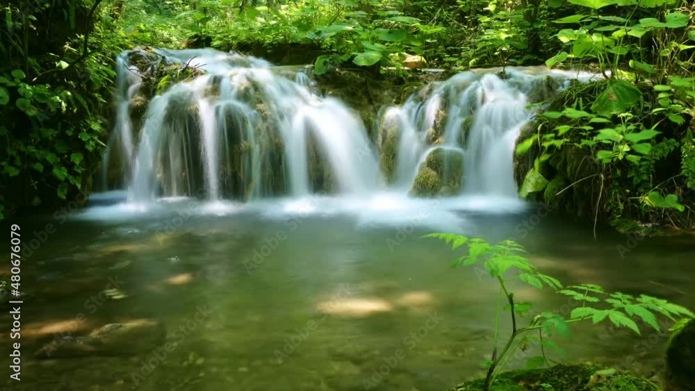 Time-lapse of flowing waterfall in the valley Time-lapse of flowing waterfall in the valley