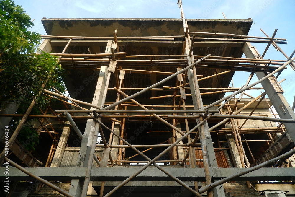Photo Illustration of Semi-Finished Building and Remaining Building Materials Such as Wood, Bamboo, Barn, Tile Roof, Sand. Everything is placed on the Grasslands Photo Illustration of Semi-Finished Building and Remaining Building Materials Such as Wood, Bamboo, Barn, Tile Roof, Sand. Everything is placed on the Grasslands
