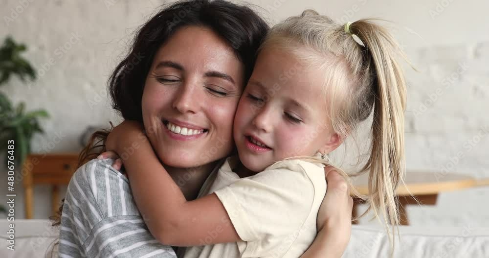 Latina woman her cute little daughter sit on sofa cuddling cheek-to-cheek enjoy moment of tenderness and caress, feeling love, close up. Family ties and bonding. Happy Mother Day, motherhood concept Latina woman her cute little daughter sit on sofa cuddling cheek-to-cheek enjoy moment of tenderness and caress, feeling love, close up. Family ties and bonding. Happy Mother Day, motherhood concept