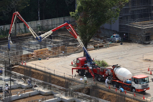 マンション建設現場のコンクリートミキサー車とコンクリート圧送車