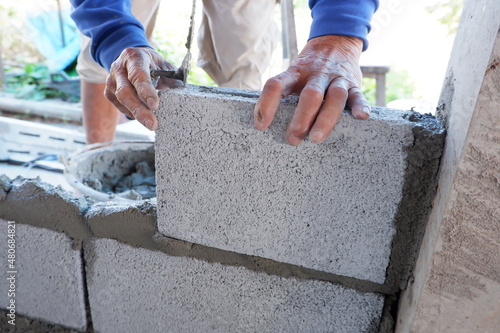 bricklayer building a wall with cement plaster, construction work.