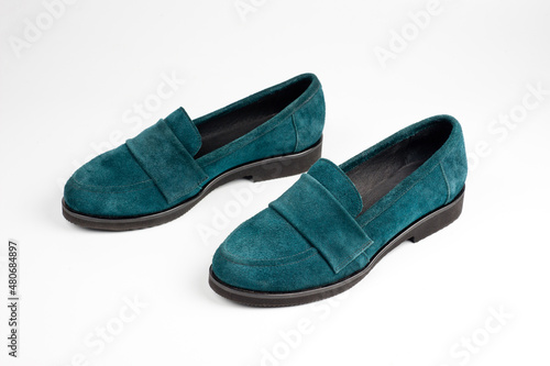 Suede dark green women's slip-on shoes with a small heel. Close-up shot.