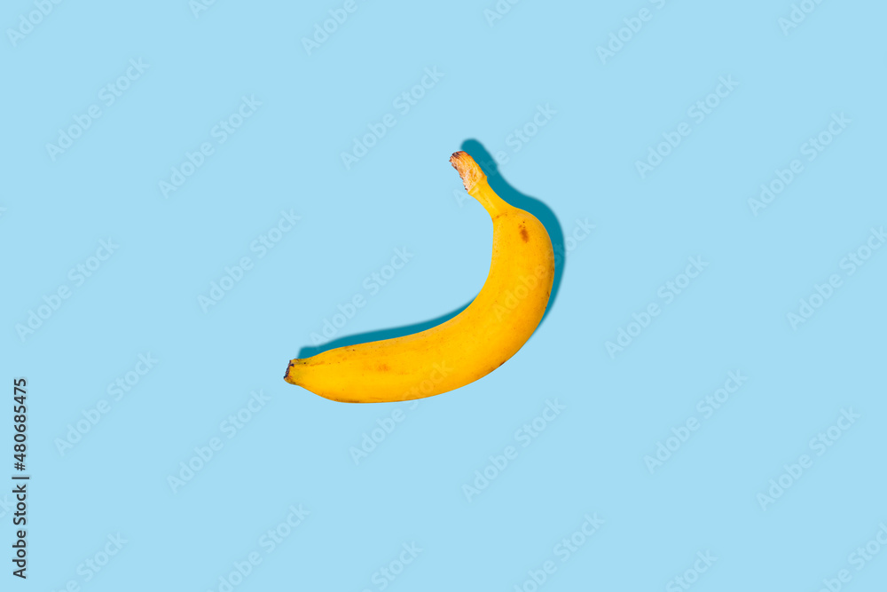Fresh ripe banana on a blue background. Top view, flat lay.