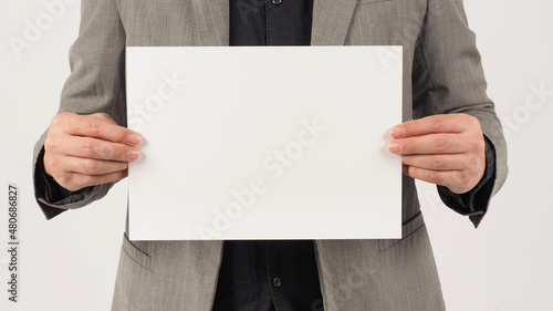 Man is wearing a gray suit and holding the paper board on white background.