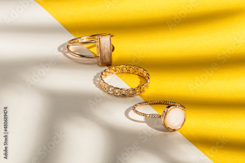gold rings palm shadow jewelry product photography sunshine warmth tropical sun flatlay colored paper backdrop