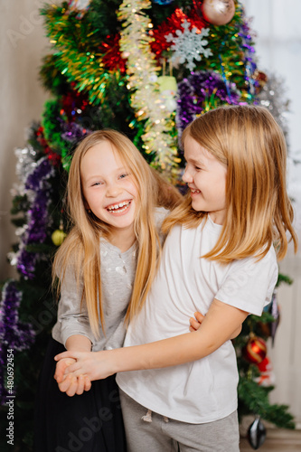  happy little girls blonde at the Christmas tree. happy childhood. foster children at home. custody of orphans. the tradition of giving gifts to children for the New Year. © Maria