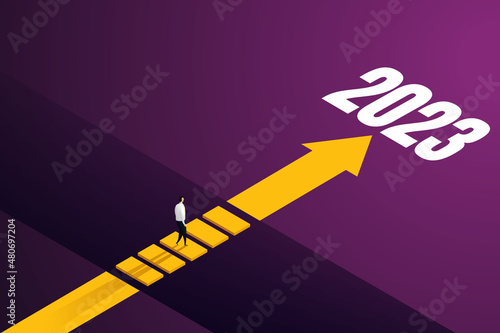 Businessmen to walk through the gap across other side through challenges of goals for 2023.