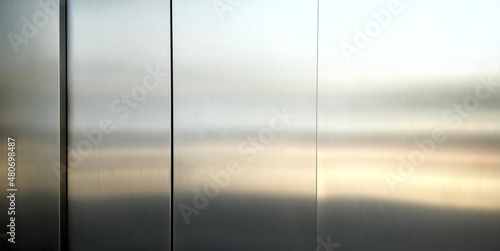 Stainless steel large sheet With light hitting the surface For background,Inside passenger elevator,Reflection of light on a shiny metal surface.