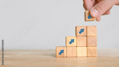 Business concept growth process. Hand putting wood cube block on top pyramid, for create icon symbol to success concept.