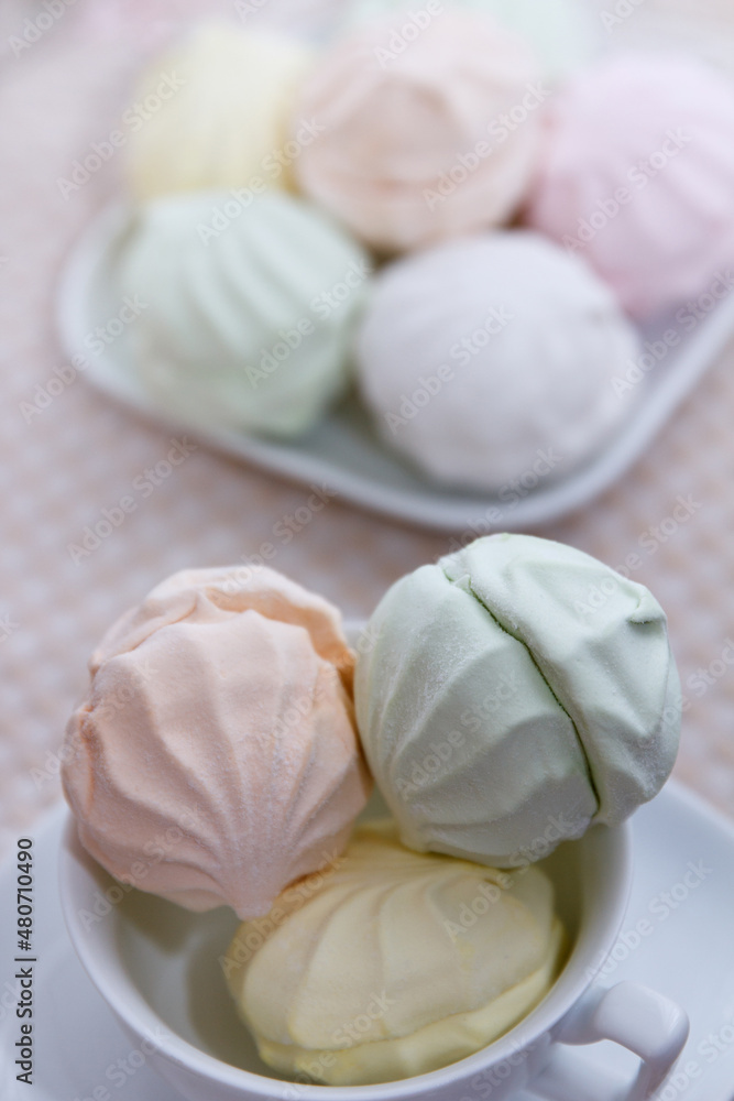 Delicious fresh multicolored marshmallow lies on a serviced table in saucers