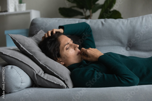 Frustrated anxious unhappy young woman lying on couch, lost in negative thoughts, pondering problem solution, suffering from loneliness or personal psychological troubles, depression concept.