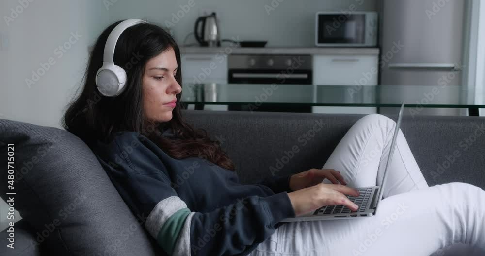Serious pretty young woman freelancer works on freelance from modern home typing email on laptop focused girl use computer for study online sitting on couch female user busy on distance internet job Serious pretty young woman freelancer works on freelance from modern home typing email on laptop focused girl use computer for study online sitting on couch female user busy on distance internet job