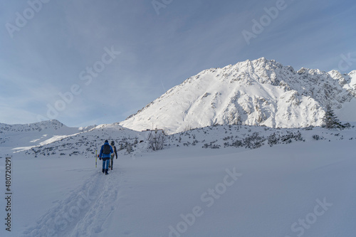 Tatra Mountains, Winter mountain landscape in the Tatras, tourists climb the snowy slopes, views of the snow-capped mountains in frosty sunny weather Poland