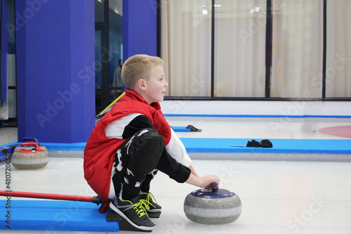 boy playing curling in a sports club