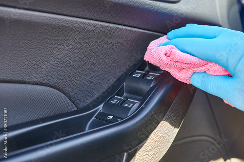 A man cleans the car with detergent and a rag. Car cleaning concept.