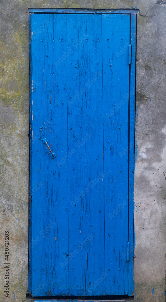 Old blue door with shutters. Old wooden door with old paint. Old blue wooden door. Peel off paint