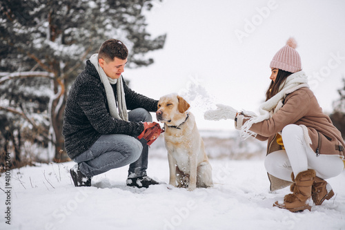 Family walking in winter park with their dog © Petro