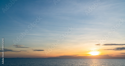 Sunset sky clouds over sea in the evening with orange sunlight golden hour, dusk sky  © Nature Peaceful 