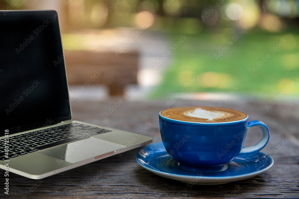 Laptop and coffee cup of latte art fresh on wooden table in cafe.. morning coffee, coffee time concept. Laptop and coffee cup of latte art fresh on wooden table in cafe.. morning coffee, coffee time concept.