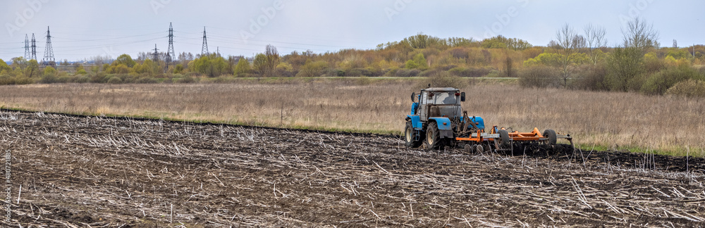 Obraz premium Tractor Plowing Field Tillage Agricultural land Farm Agriculture Preparing the soil for sowing. Plow Machine Equipment Working Village Season