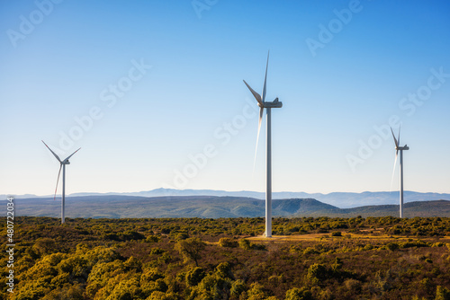 Wind turbines on a beautiful blue sky in a mountain wind farm in Sardinia. Renewable energy concept, green energy generation. Energy industry.