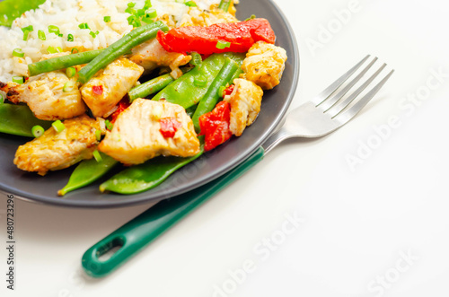 Chicken breast pieces in a Thai red curry sauce made with coconut cream, red chillies, lemongrass, lime leaf, with fragrant rice, red peppers, mange tout, and green beans