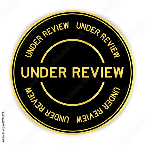 Black and gold color round sticker with word under review on white background