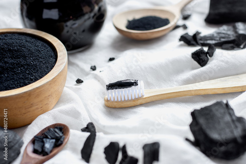 Black charcoal toothpaste with finely ground charcoal is placed on a white cloth. photo