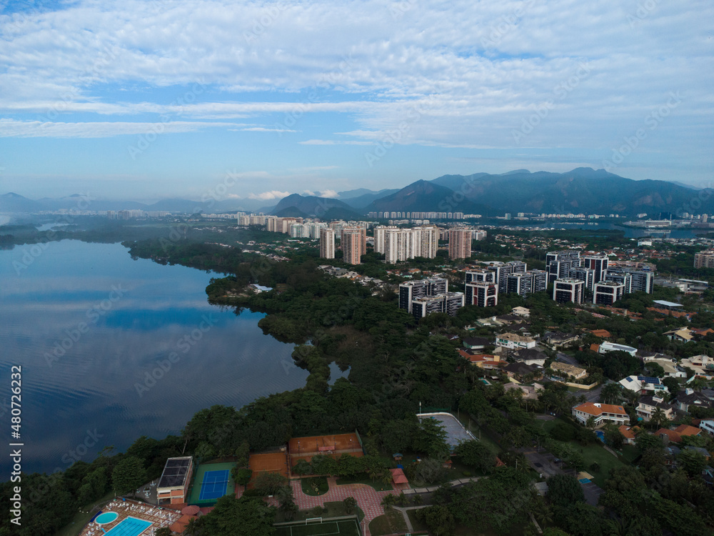 Aerial view of Marapendi lagoon and some houses in Barra da Tijuca. In the background hill of Rio de Janeiro, Brazil. Dawn. Sunny day with some clouds. Drone photo