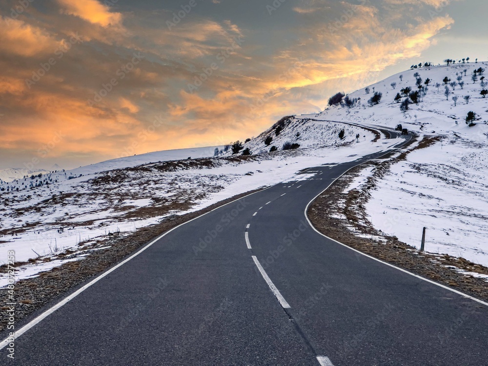 Winter road in the mountains against the background of dawn.