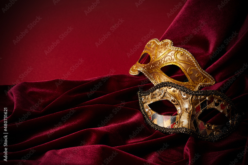 Luxury venetian mask on dark red background. Carnival masquerade fantasy mask - obrazy, fototapety, plakaty 