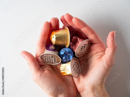 Women's hands hold a lot of used aluminum capsules. The concept of product reuse. Modern ways of storing coffee