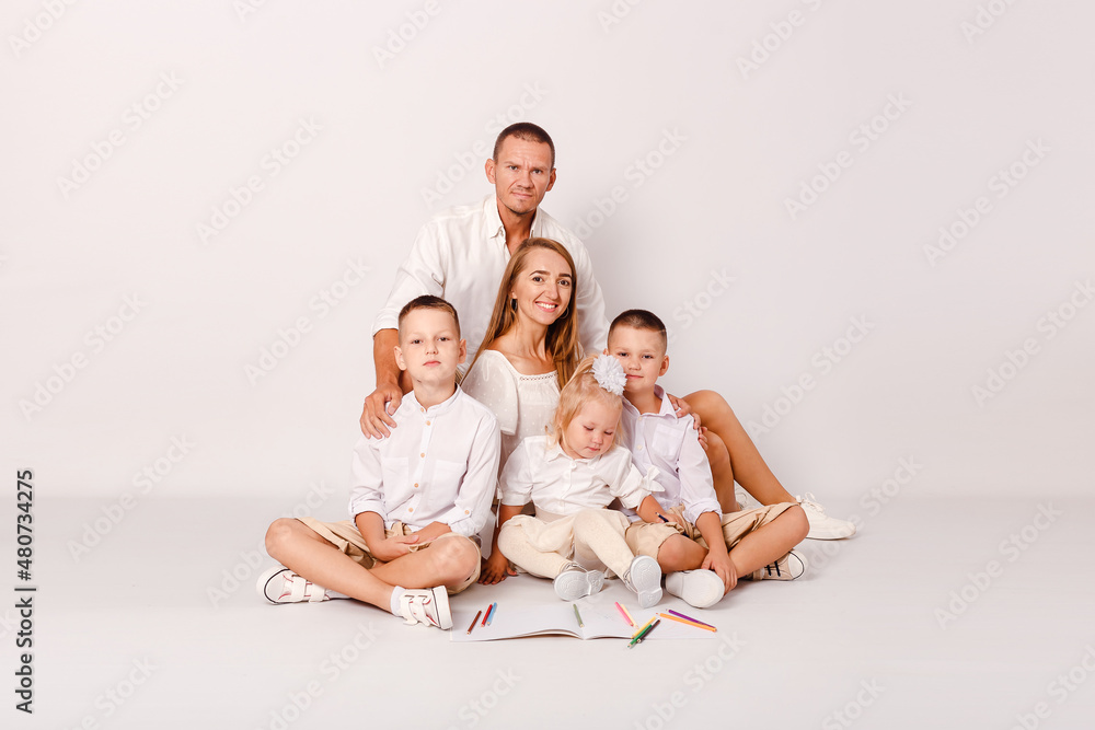 happy parents and three beautiful children embrace on a white background
