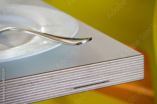Birch plywood laminate topped table with white plate and fork close up