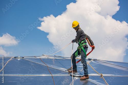 Male workers rope access height safety connecting with a knot safety harness, to ascending, construction site oil tank dome.