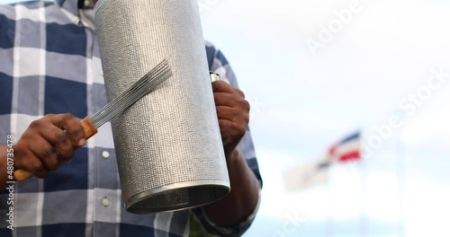 dominican man playing tambora guira with dominican flag
