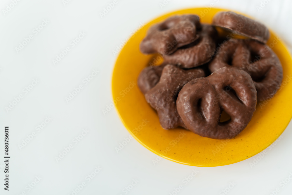 Gingerbread in chocolate lies on a yellow plate. Place for an inscription. Gingerbread in chocolate lies on a yellow plate. Place for an inscription.