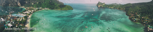 Phi Phi Don, Thailand. Panoramic aerial view of Phi Phi Island coastline, homes and beach from drone on a hot sunny day