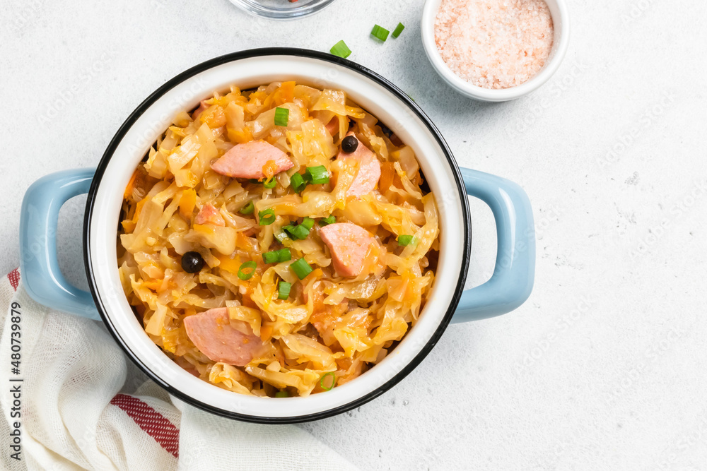 Keto cabbage stew with kielbasa in a pot. Top view, copy space. Keto cabbage stew with kielbasa in a pot. Top view, copy space.