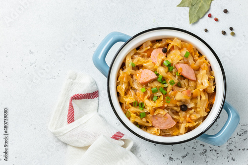 Potato cabbage kielbasa stew in a pot. Top view, copy space.