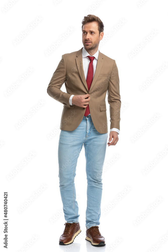 attractive businessman holding one hand on his button attractive businessman holding one hand on his button