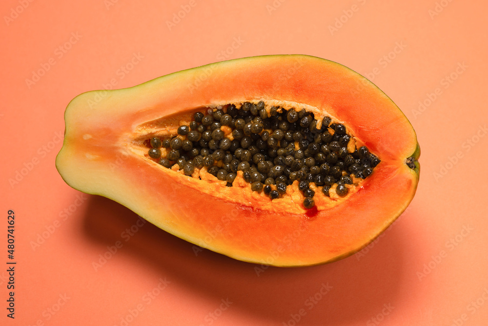 Papaya fruit on a orange background. Half papaya. Papaya fruit on a orange background. Half papaya.
