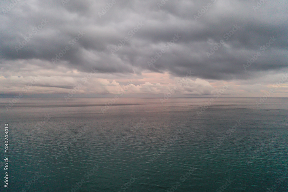 Fototapeta premium aerial foto of dramatic morning sky, glowing clouds over calm open water